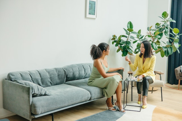 two women discussing on couch