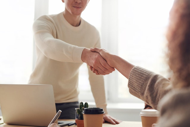 people shaking hands across table