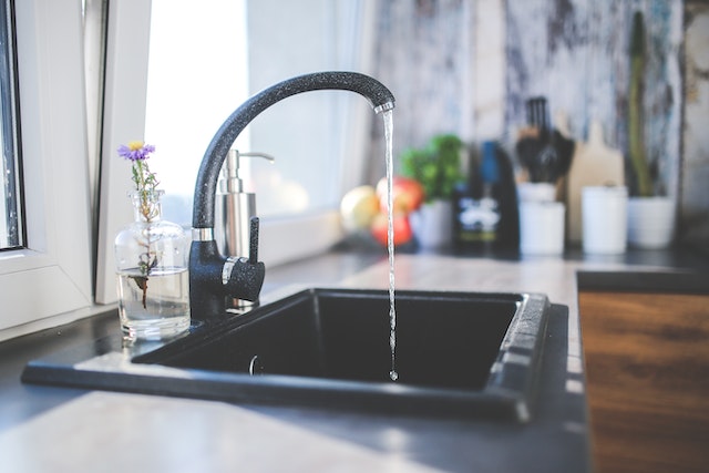 Water flowing from black kitchen sink